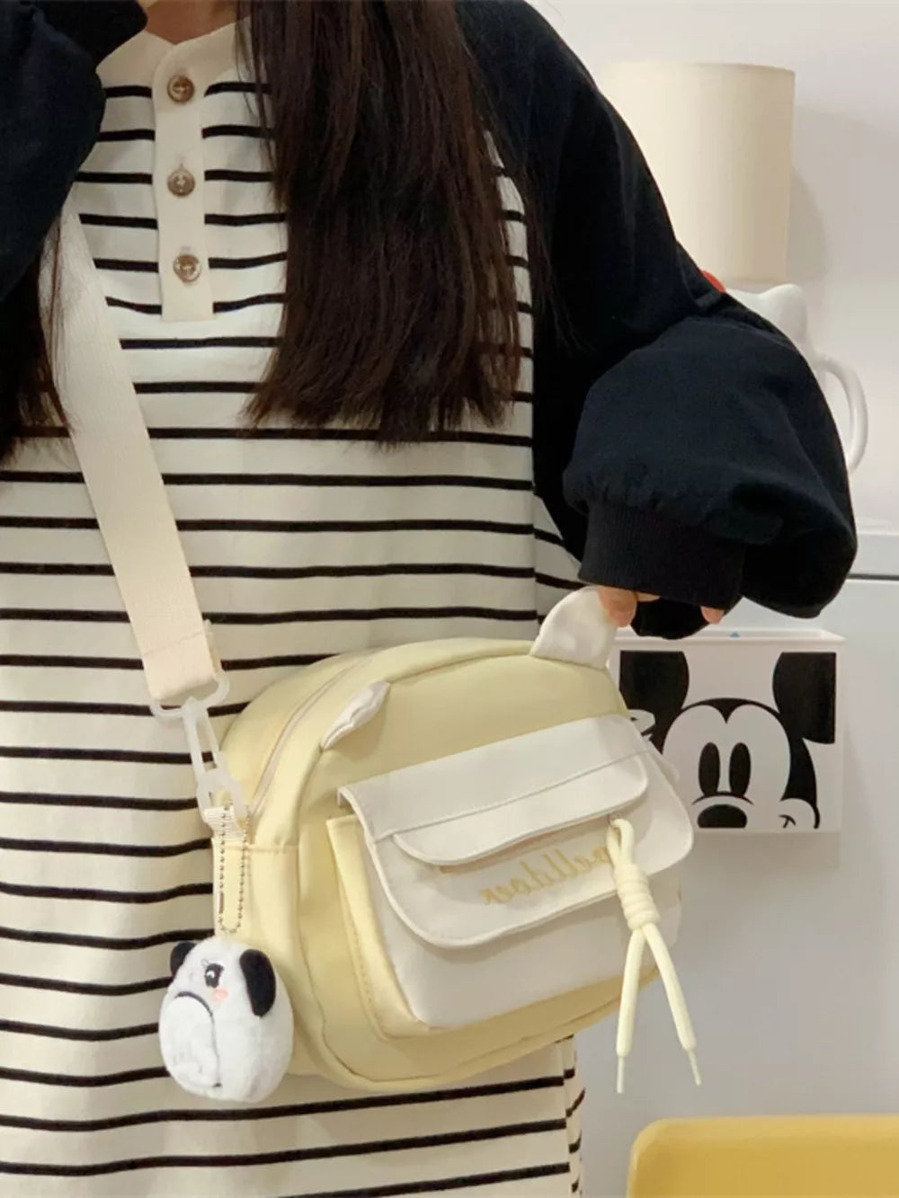 Yellow crossbody bag with cat ears and a plush dog charm, featuring a white pocket detail.