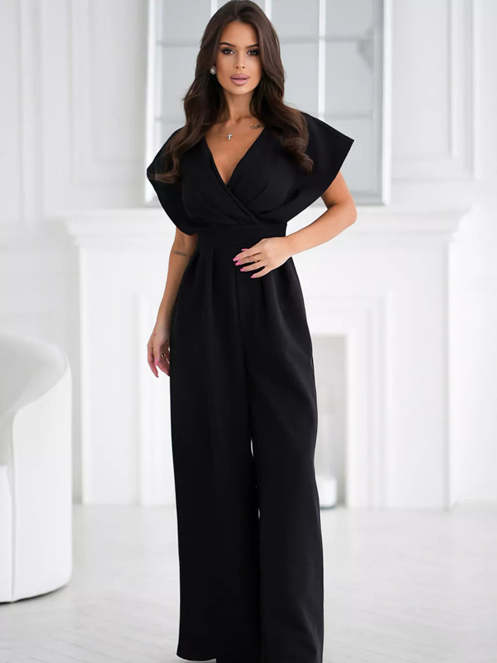 Black wide-leg romper with surplice neckline and flutter sleeves.