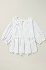 White babydoll blouse with gathered neckline, balloon sleeves, and tiered peplum hem.