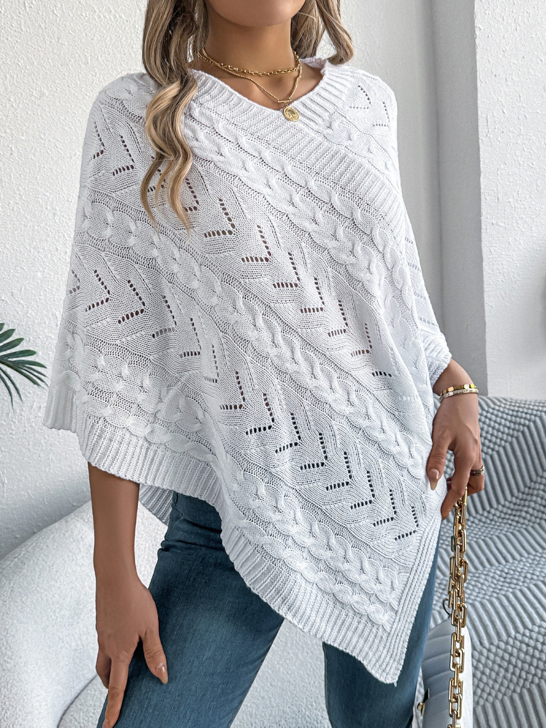 White cable knit poncho with chevron detail and open knit accents