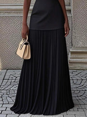 Black pleated maxi dress with a boat neck and a smooth bodice.