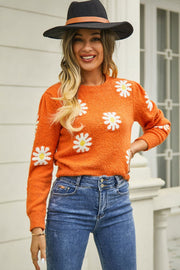 Orange textured knit sweater with daisy motif, crew neck, long sleeves.