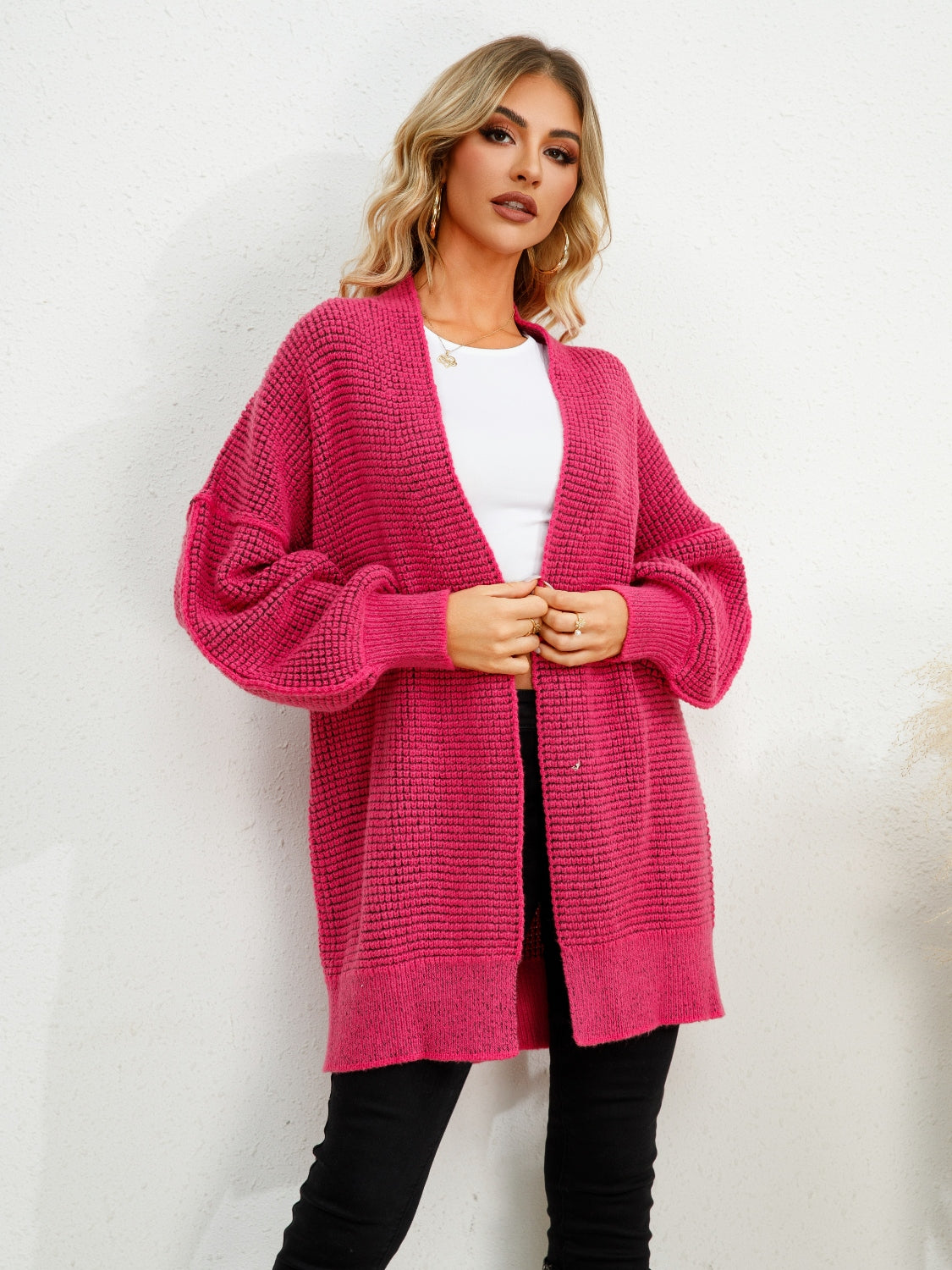 Textured cocoon cardigan in hot pink with balloon sleeves and an open front.