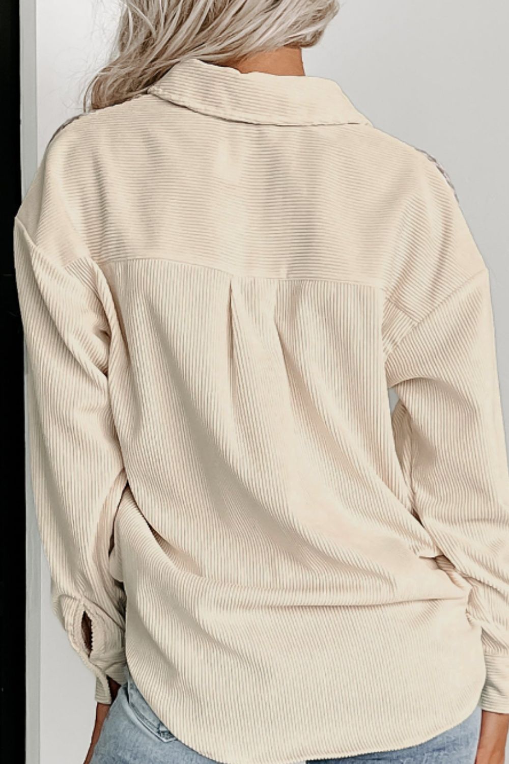 Beige corduroy shacket with a classic collar and button cuffs, featuring a yoke and back pleats.