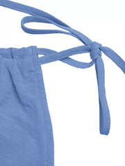 Blue tie-strap romper detail showing adjustable shoulder ties and elasticized waist.