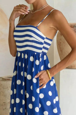 Blue polka dot maxi dress with striped bodice, spaghetti straps, smocked waist, and pockets.
