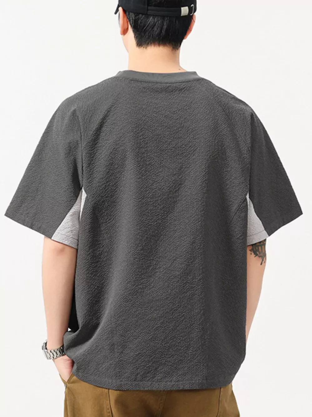 Men's dark gray textured t-shirt with contrast light gray panels and crew neck.