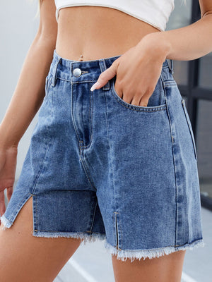 Split-front denim shorts in dark blue with frayed hem and pockets.