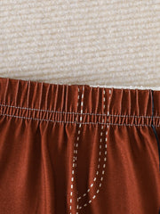 Baby shorts with elastic waist and faux pocket detail in rust color