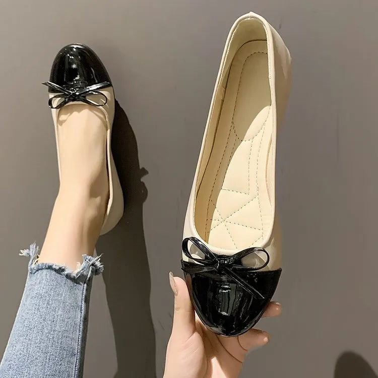 Patent bow ballet flats in black and white with a cap toe detail.