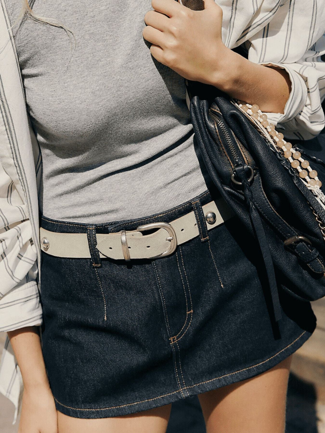 Dark blue denim mini skort with button closure and contrast stitching.