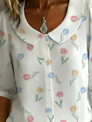 Peter Pan collar blouse with a floral print in pink, blue, and yellow tulips on white.