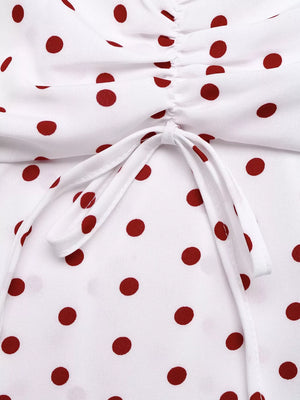 White polka dot camisole with ruched detail and tie front.