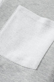 Colorblock sweatshirt in light gray with a contrasting white pocket detail.