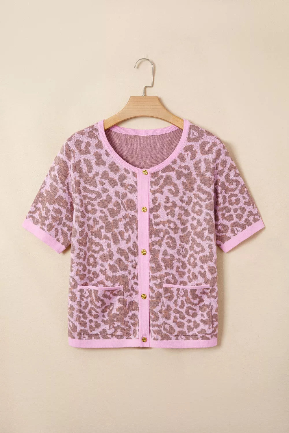 Short sleeve leopard print cardigan with button front and pockets in acrylic blend.
