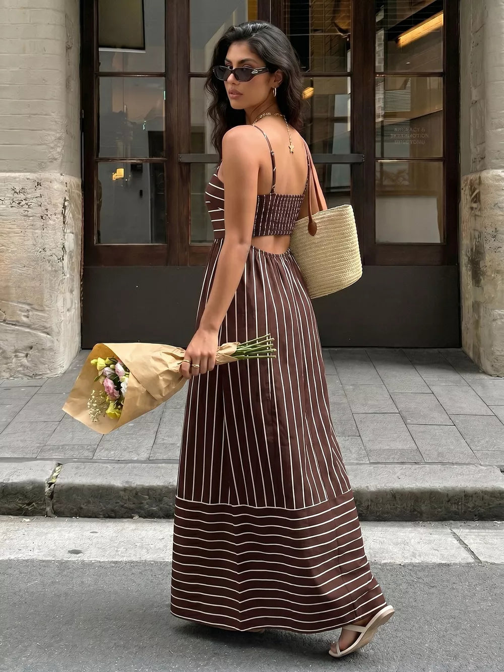 Brown striped maxi dress with smocked bodice and cutout detail.