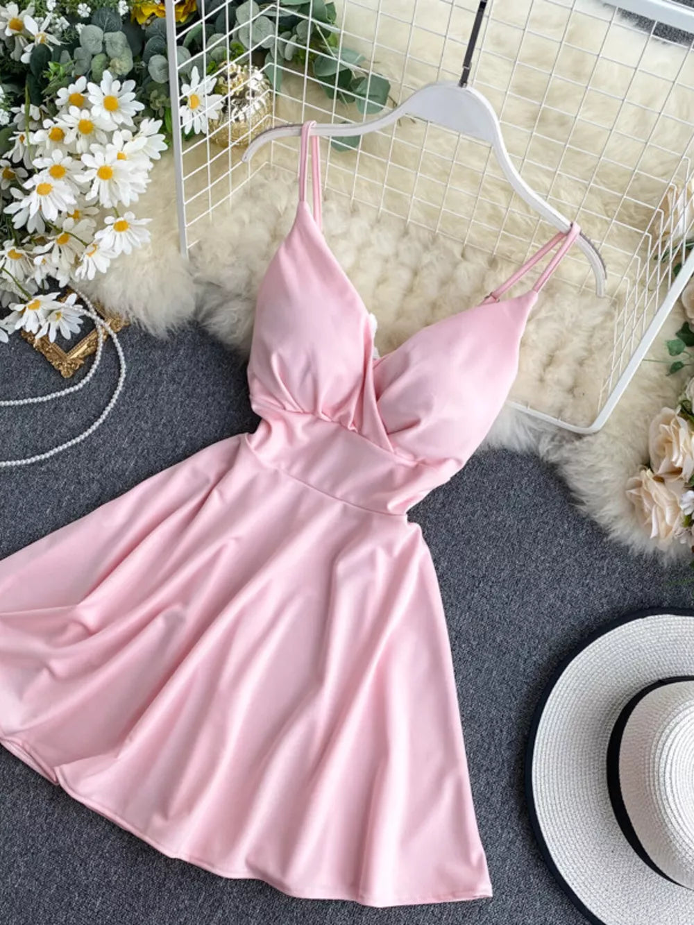 Pink spaghetti strap mini dress with V-neck and adjustable straps.
