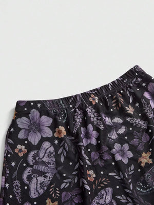 Black midi skirt with a whimsical floral and butterfly print, featuring an elastic waistband.