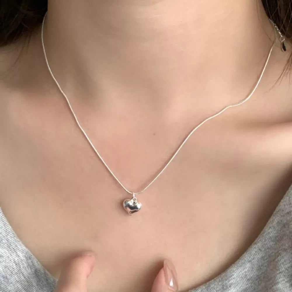Sleek sterling silver heart pendant necklace with a delicate chain.
