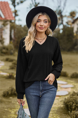 Black textured cable knit V-neck sweater with long sleeves.