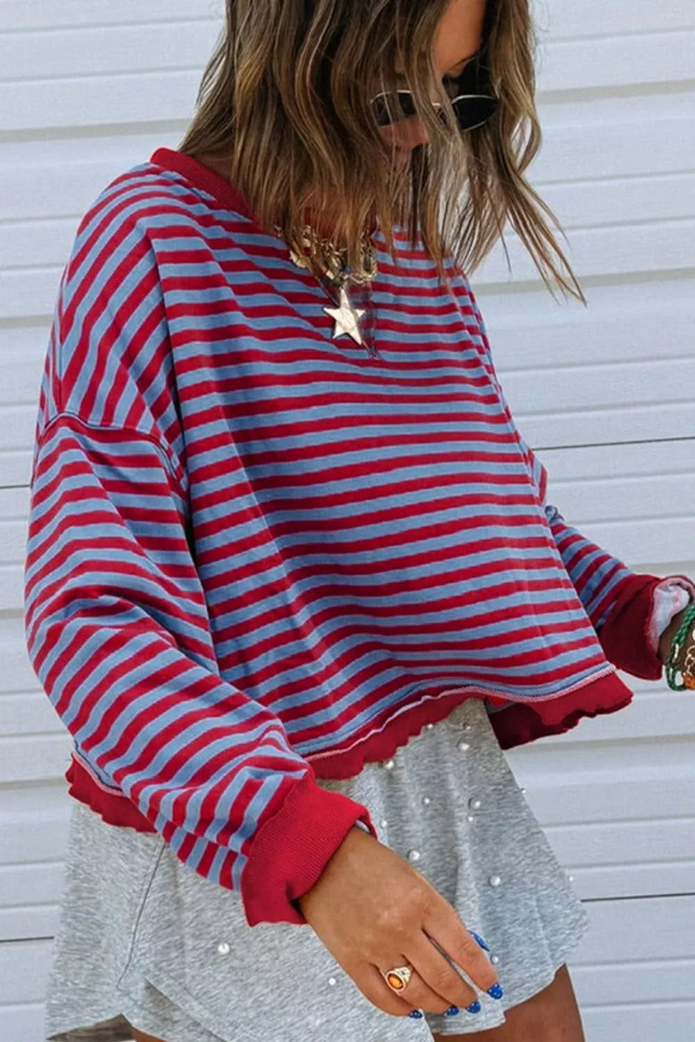 Striped sweatshirt with red and blue horizontal stripes, crew neck, and contrast red trim.