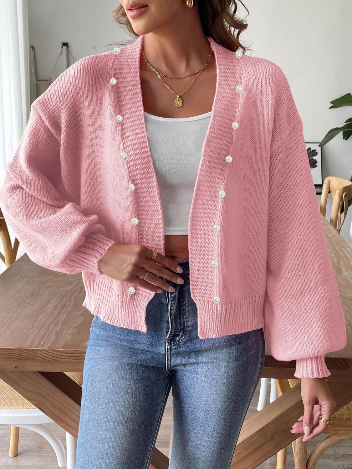 Blush pink bubble sleeve cardigan with pearl buttons and ribbed cuffs.