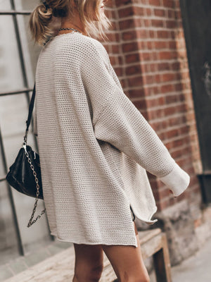 Beige oversized open-knit sweater dress with crew neck and cuffed sleeves.