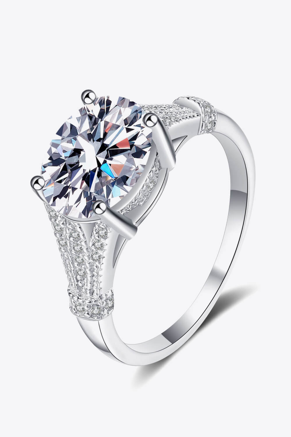 Silver pavé-set moissanite solitaire ring with a round-cut center stone.