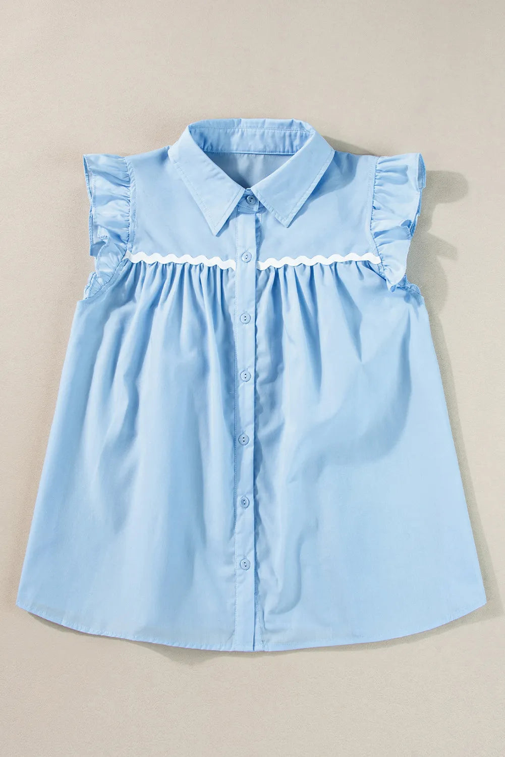 Light blue poplin blouse with ruffled yoke and sleeves, white scalloped trim, and button front.