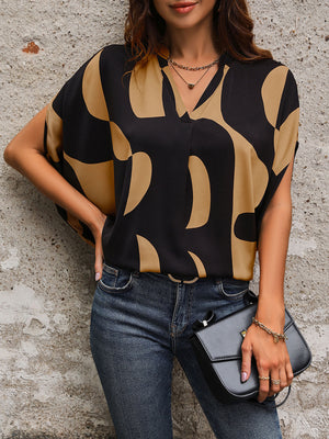 Black abstract print batwing blouse with V-neck and short sleeves.