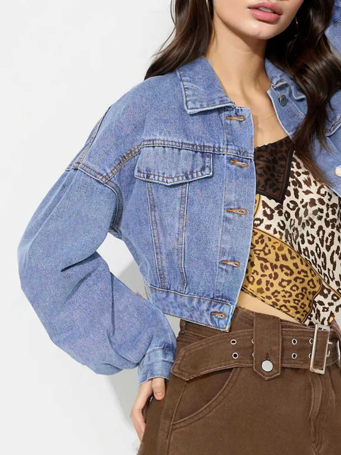 Cropped denim jacket in medium wash with balloon sleeves and buttoned front.