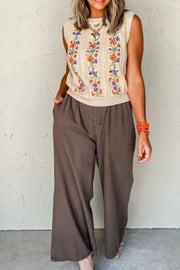 Beige cable knit vest with floral embroidery and a crew neck.