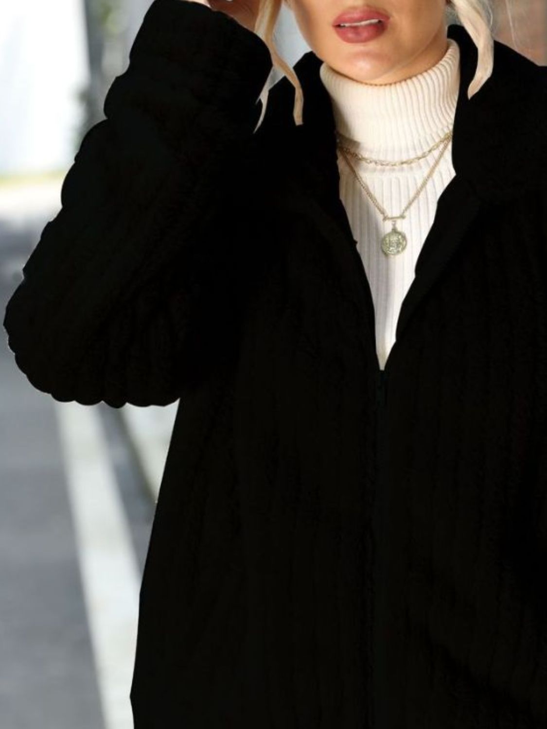 Black zip-up jacket with a plush ribbed collar, shown layered over a white turtleneck.