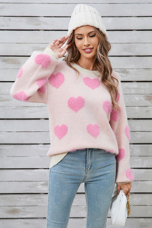 Blush pink fluffy knit sweater with allover pink hearts, crewneck, and long sleeves.