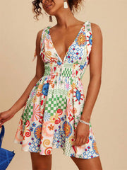 Playful printed mini dress with tied straps, V-neck, smocked waist, and colorful sun and checkered patterns.