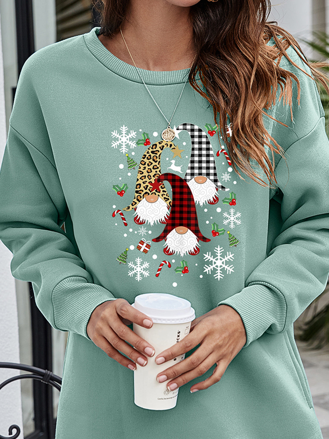 Sage green tunic sweatshirt with festive gnome and snowflake graphic.