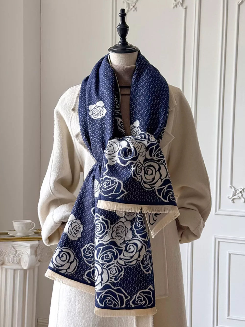 Elegant blue floral pattern scarf with fringe detail and diamond weave.