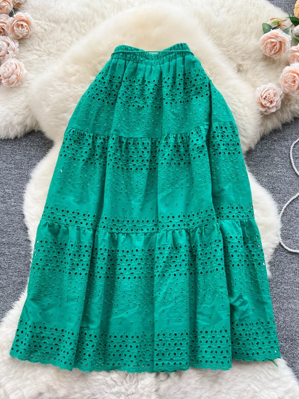 Green eyelet tiered maxi skirt with a ruffled hem and elastic waistband.