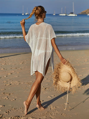 White crochet beach cover-up with daisy appliqué, short sleeves, and side slits.