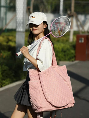 Pink quilted sports racket backpack with diamond pattern and side pockets.