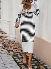 Striped knit midi dress in white and black with flared sleeves and a v-neck.