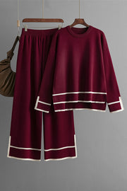 Burgundy acrylic loungewear set with round neck top and sweater pants, featuring white stripe trim.