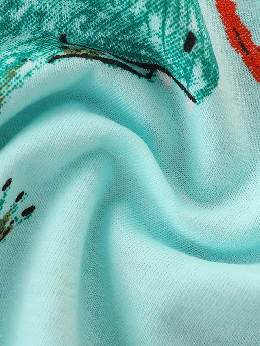 Light blue cotton toddler t-shirt with a green dinosaur graphic and red accents.