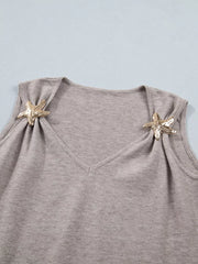Grey V-neck knit vest with gold star embellishments on shoulders.