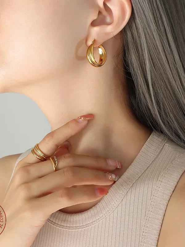 Gold double-band hoop earrings with a sculpted design.