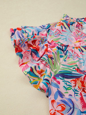 Tropical floral print cotton blouse with ruffled short sleeves and mock neck.