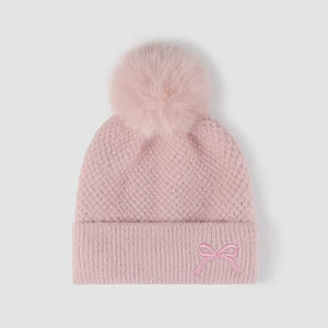 Pink textured knit baby beanie with pom-pom and embroidered bow detail
