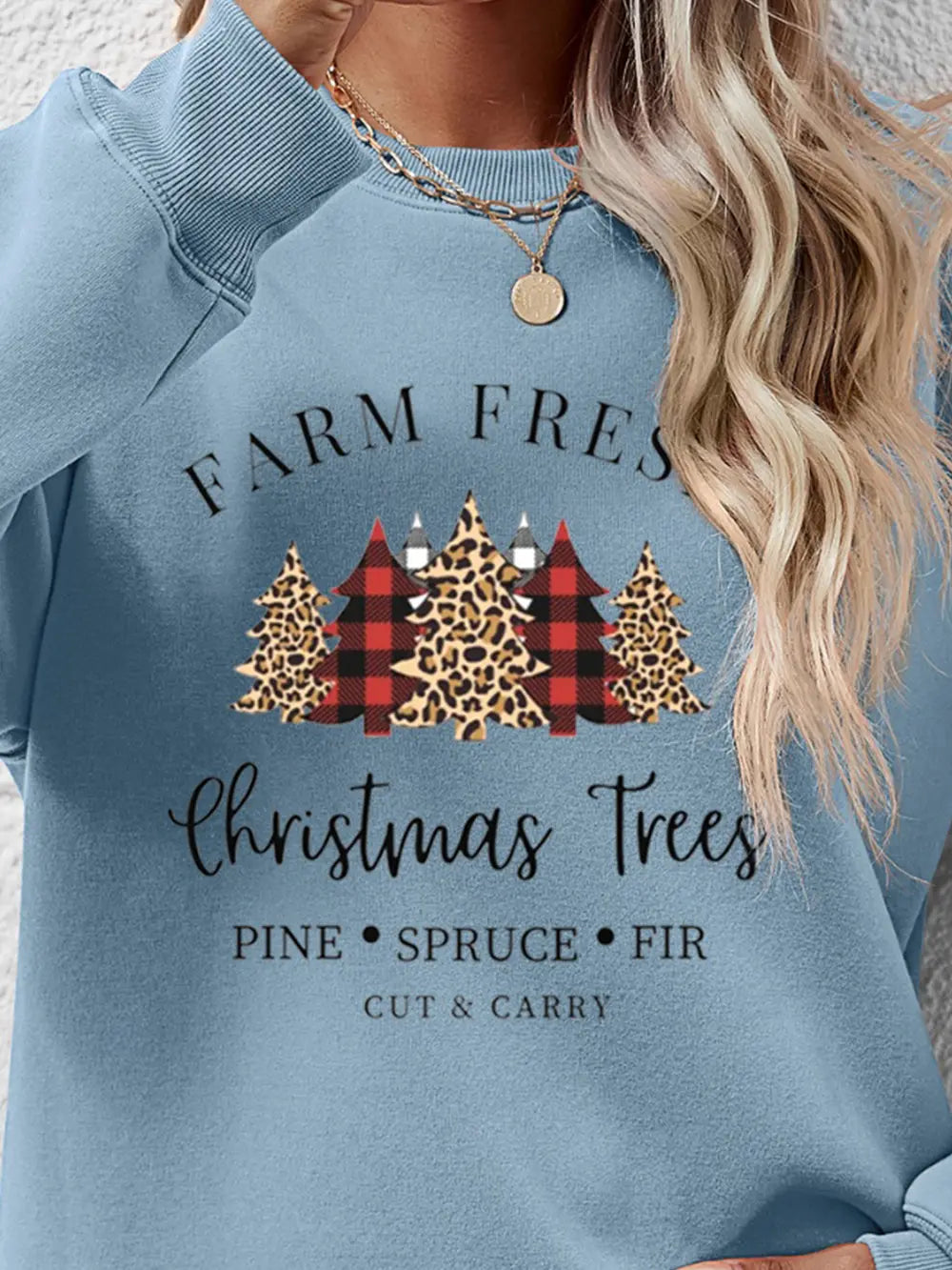 Misty Blue crewneck sweatshirt with Christmas trees graphic, plaid and leopard patterns, and text.
