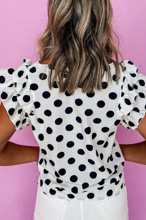 Polka dot blouse with flutter sleeves and V-neck.