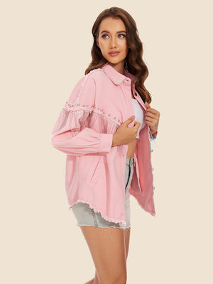 Dusty pink denim trucker jacket with fringe and stud embellishments on sleeves and hem